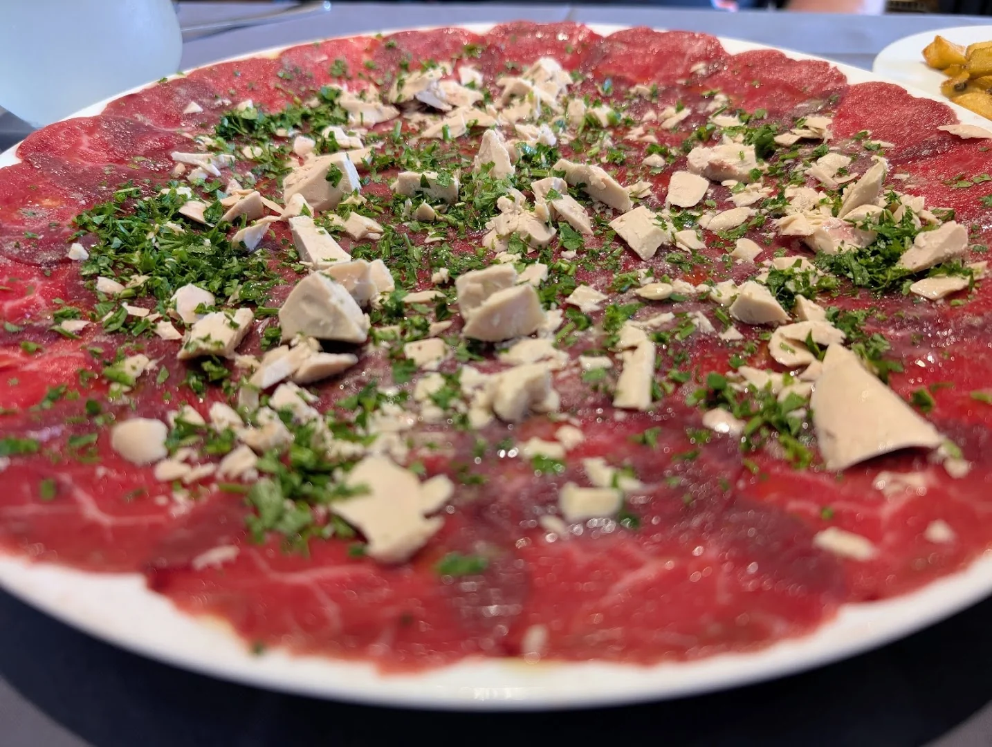 La Plancha, carpaccio de bœuf en fines tranches, copeaux de parmesan et roquette